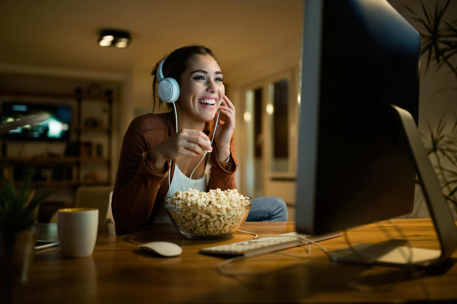 Mulher feliz comendo pipoca e assistindo filme no PC
